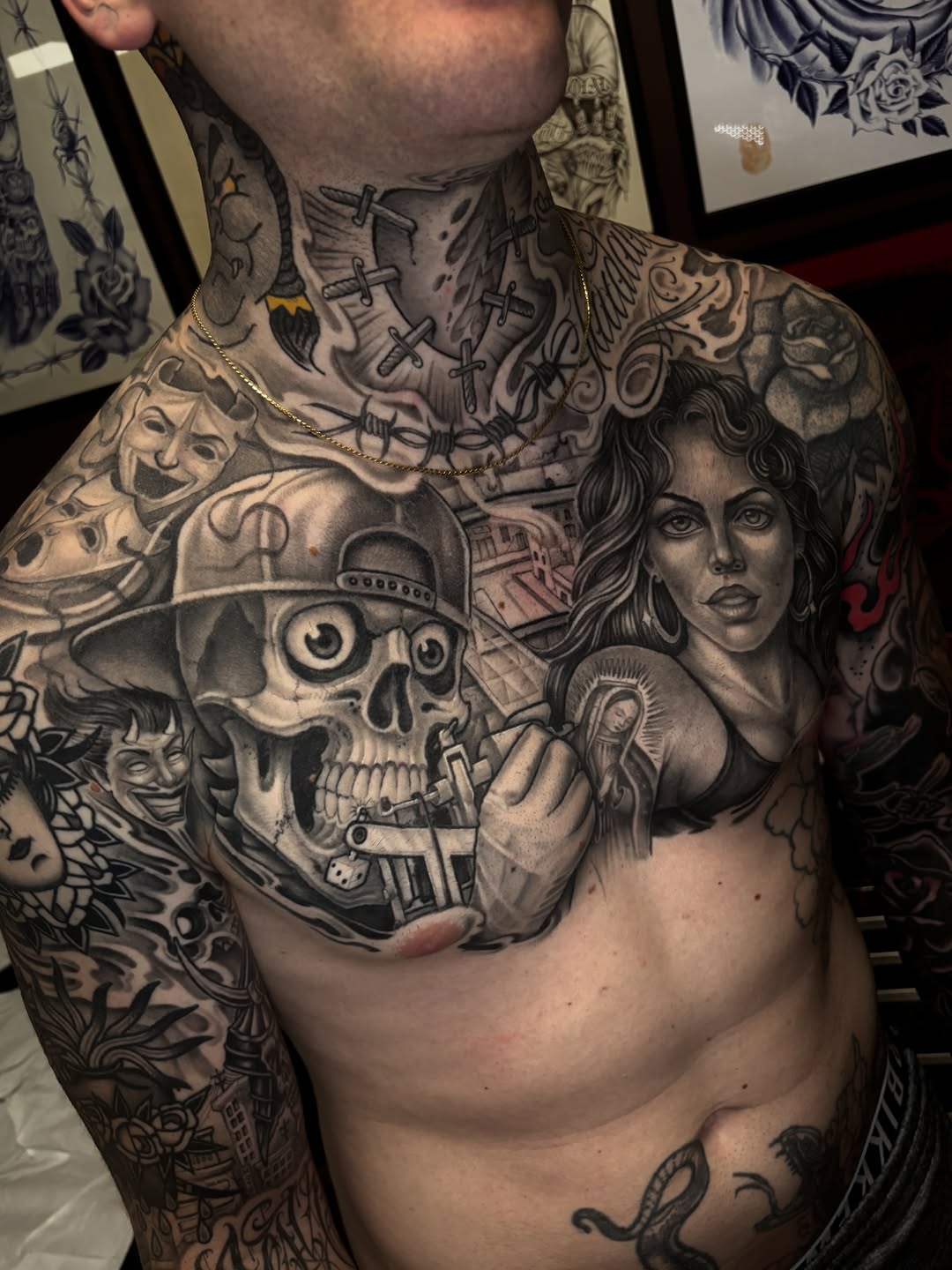 Chest and neck tattoo featuring a skull wearing a hat, a woman's face, crosses, and ornamental designs in black and grey shading.