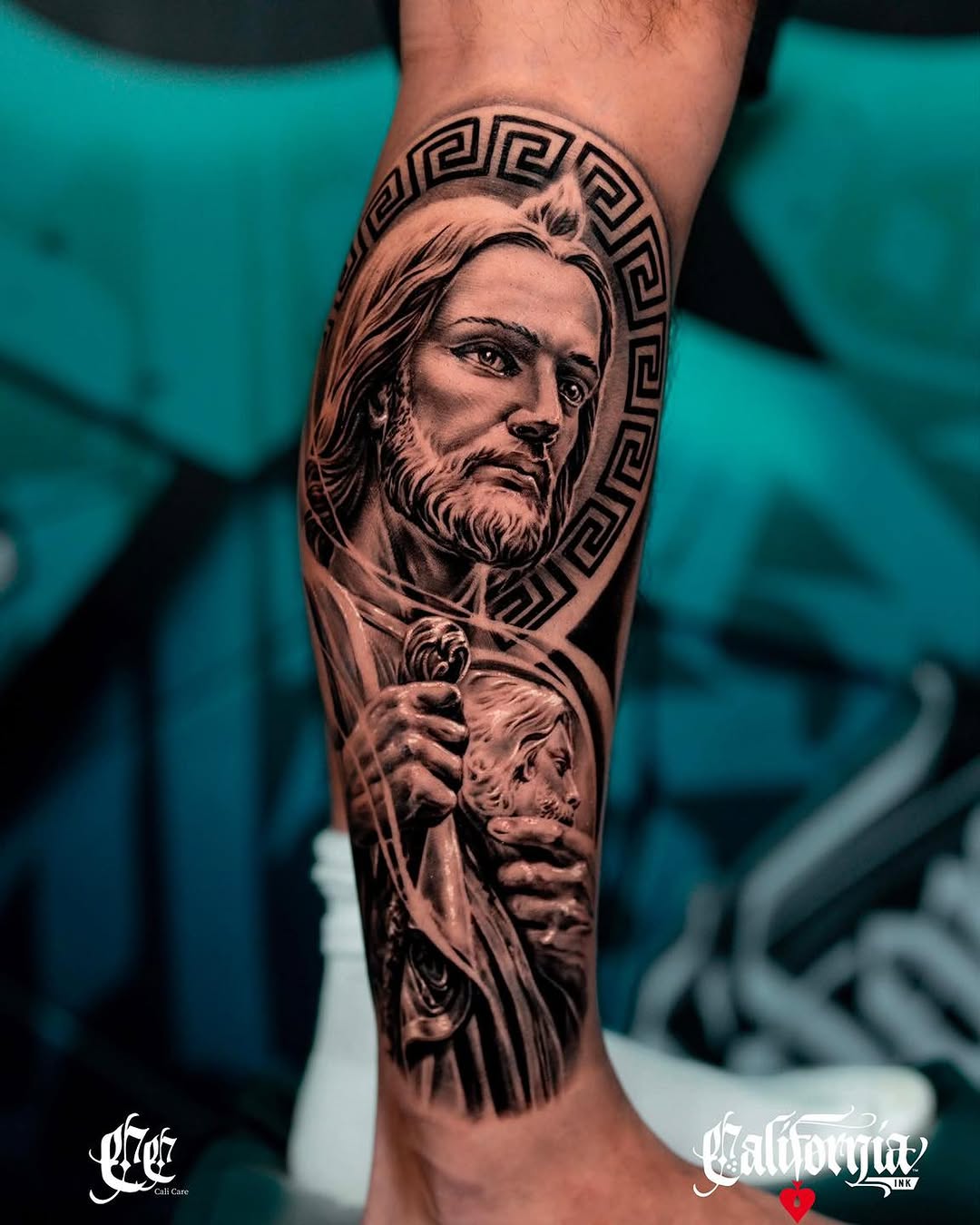 Bearded man's portrait with Greek key pattern halo and child's face below, rendered in black and grey shading on calf.