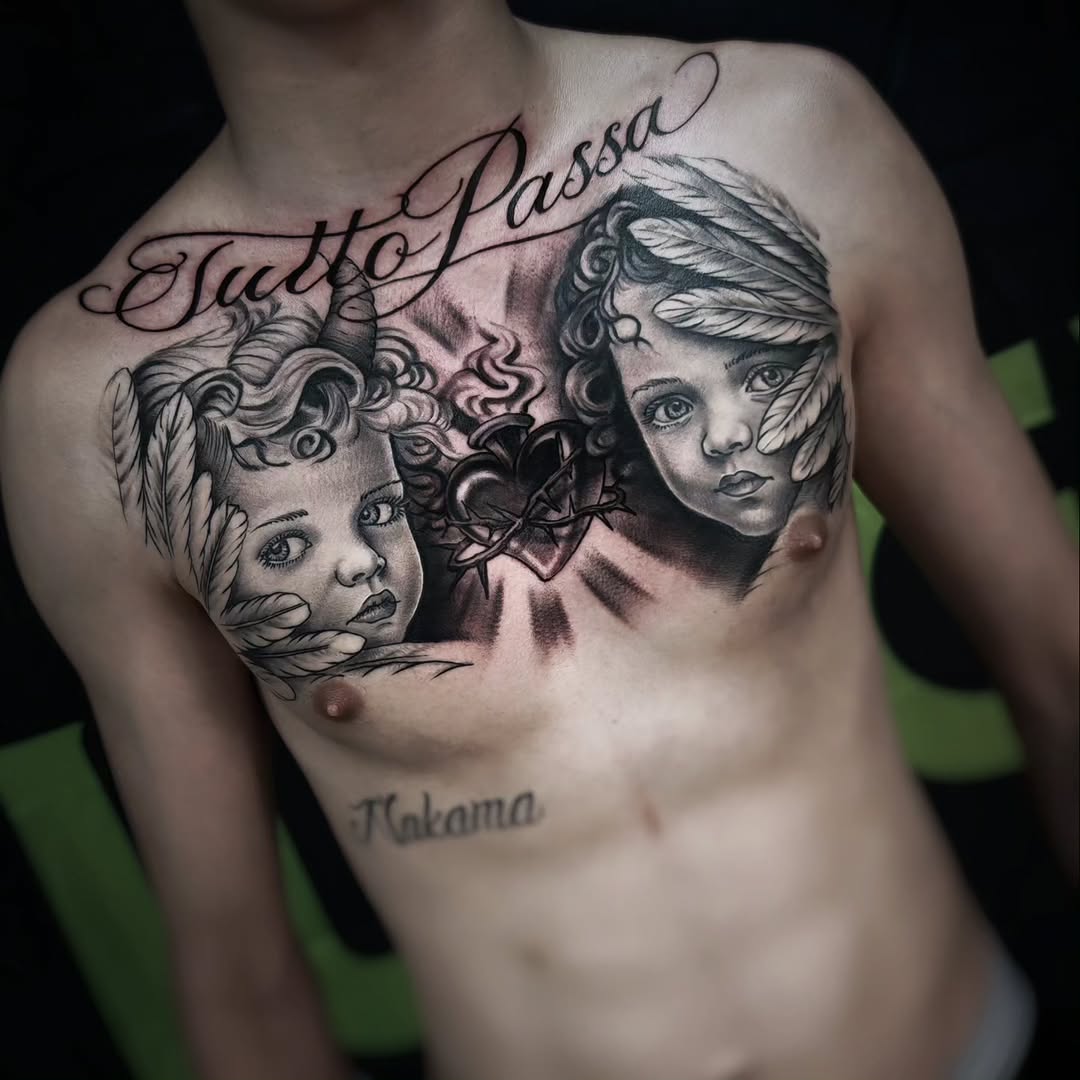 Two detailed female faces with ornate feathered headdresses and a decorative heart between them on the chest, rendered in black and grey with soft shading.