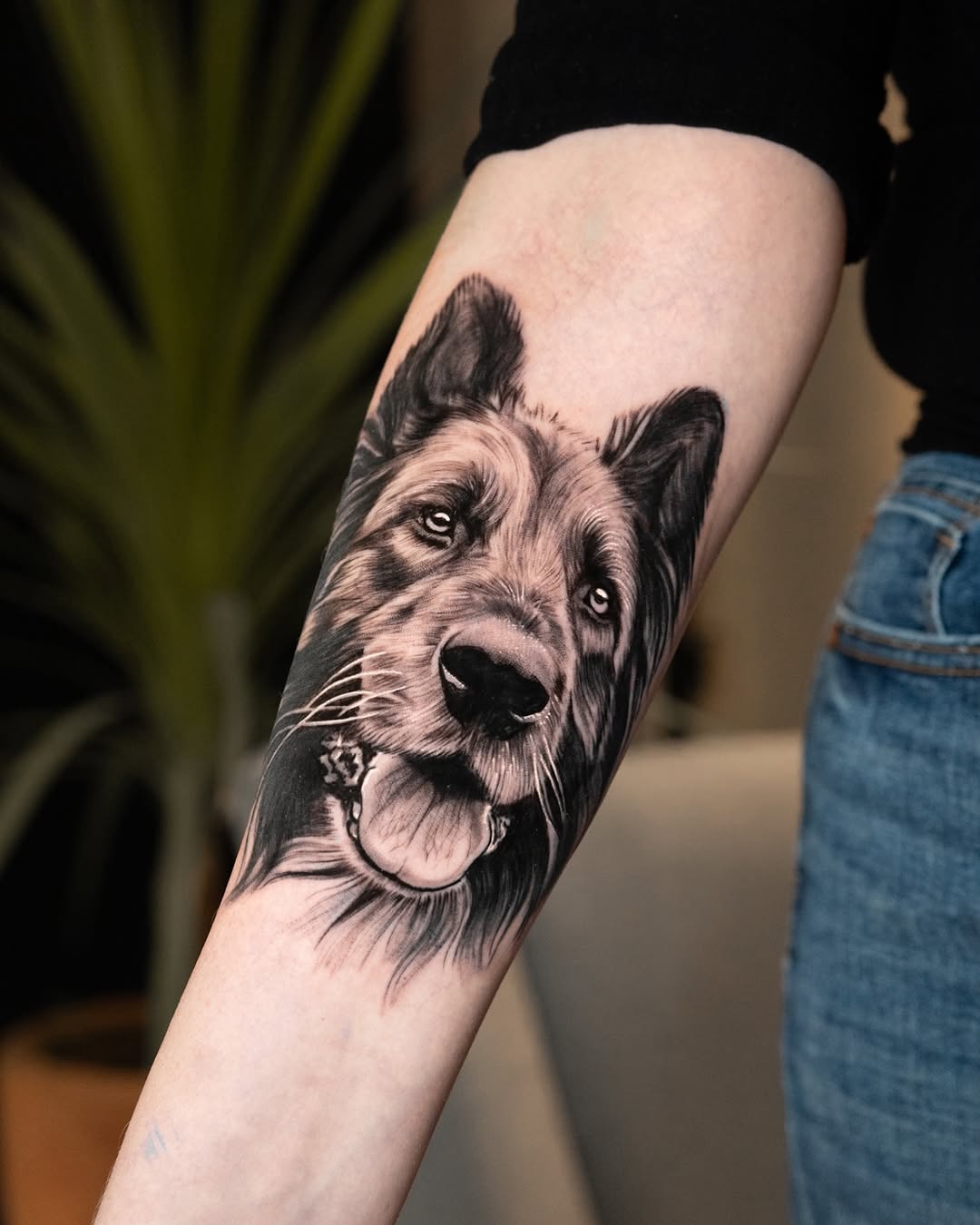 Black and grey portrait of a smiling Corgi with detailed fur texture and expressive eyes on an upper arm.