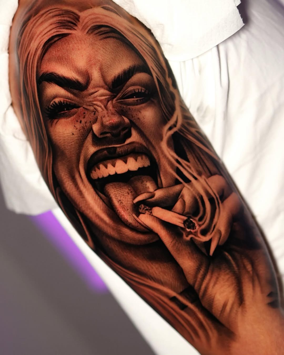 Realistic portrait tattoo of a woman's face with expressive features and a cigarette, rendered in black and grey shading on the forearm.