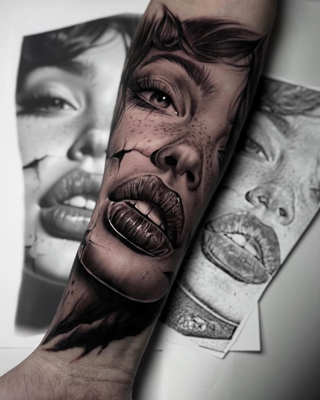 Realistic black and grey portrait tattoo on forearm featuring a woman's face with dramatic expression, freckles, and detailed shading.