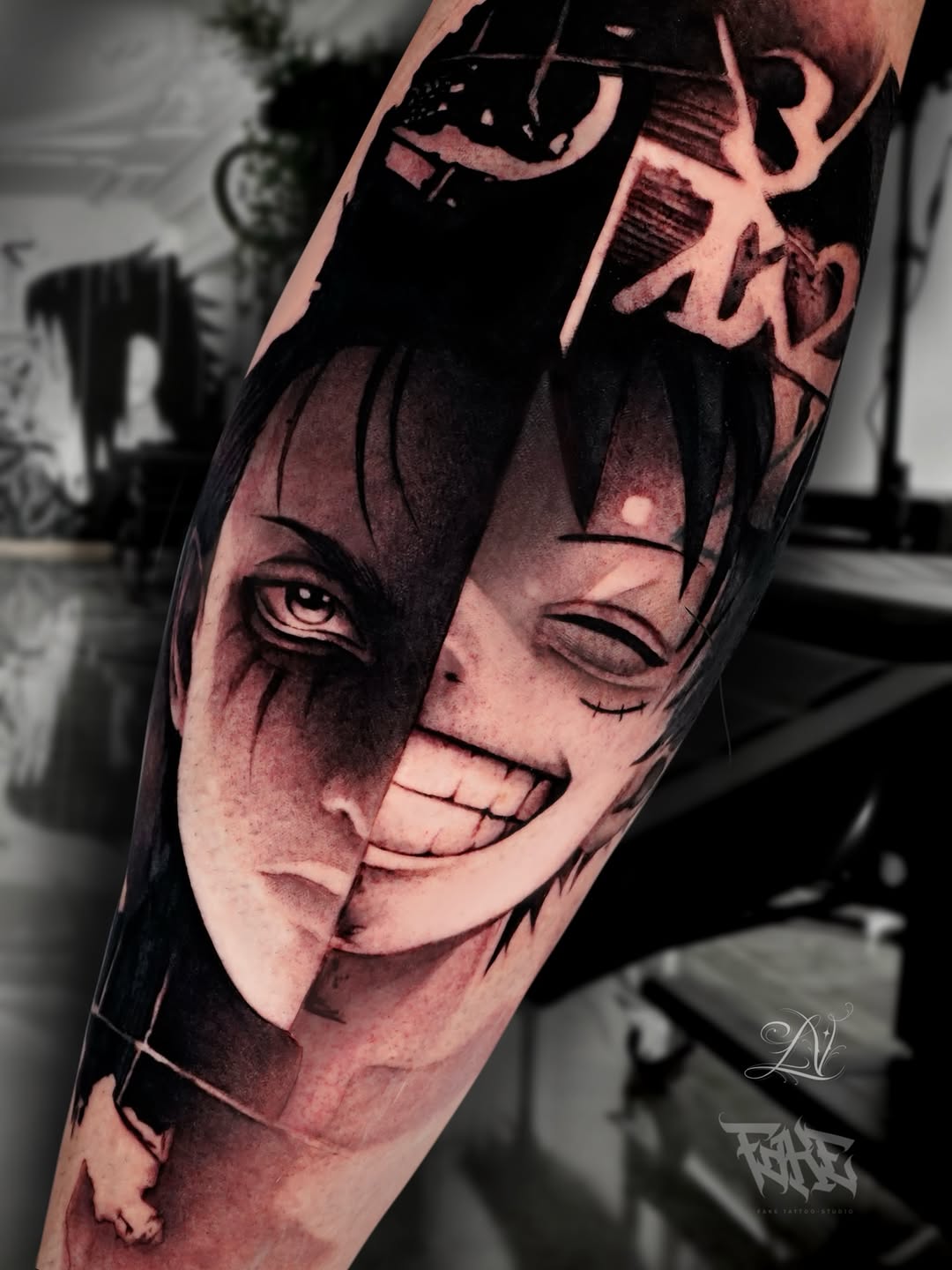 A split-face portrait tattoo on an arm showing contrasting expressions with detailed shading in black and grey tones.