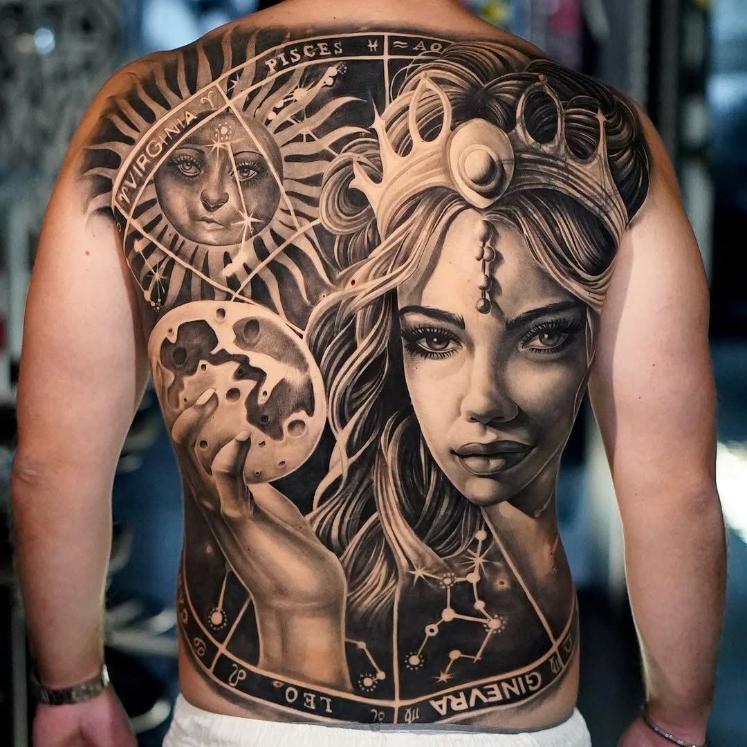 Back tattoo featuring a woman's face with flowing hair, sun and moon imagery, zodiac symbols, and constellation details in black and grey shading.
