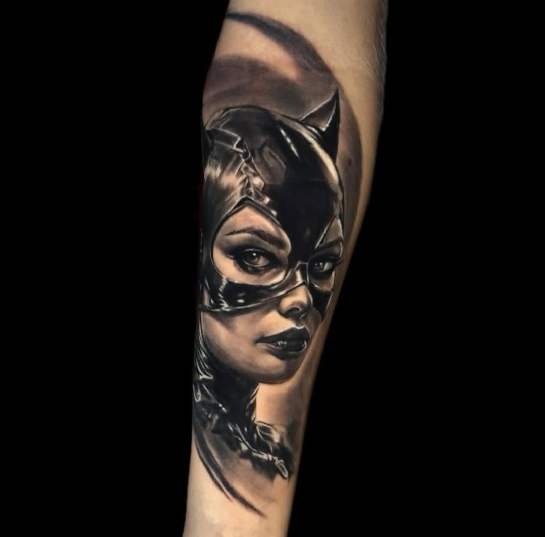 Woman's face wearing a black cat mask with pointed ears, rendered in black and grey shading on the forearm.