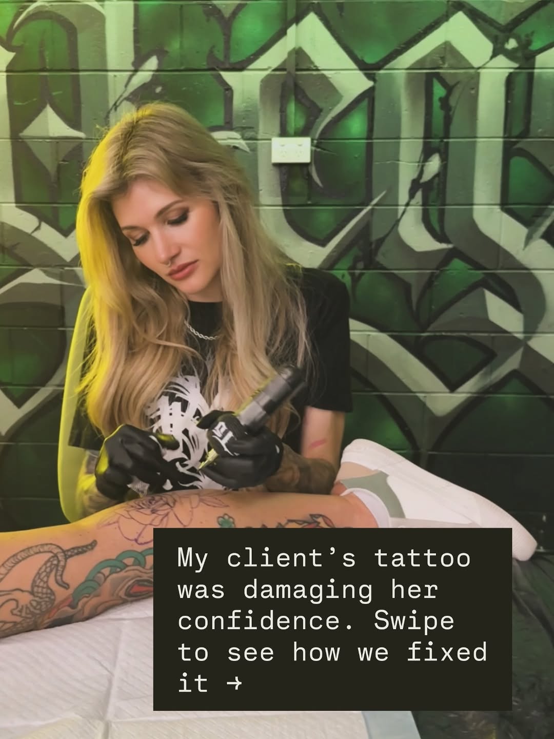 Tattoo artist working on client's arm tattoo featuring serpent and decorative elements in black and grey shading.