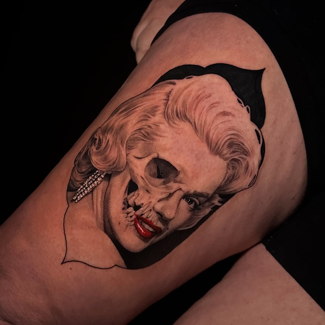 Portrait tattoo on upper arm showing a face with wavy hair, red lips, and pearl earring, rendered in black and grey with smooth shading.