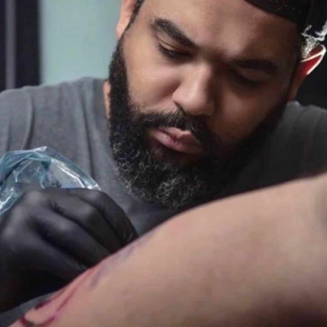 Black and grey realistic tattoo on upper arm showing detailed shading and smooth gradients in monochrome ink.